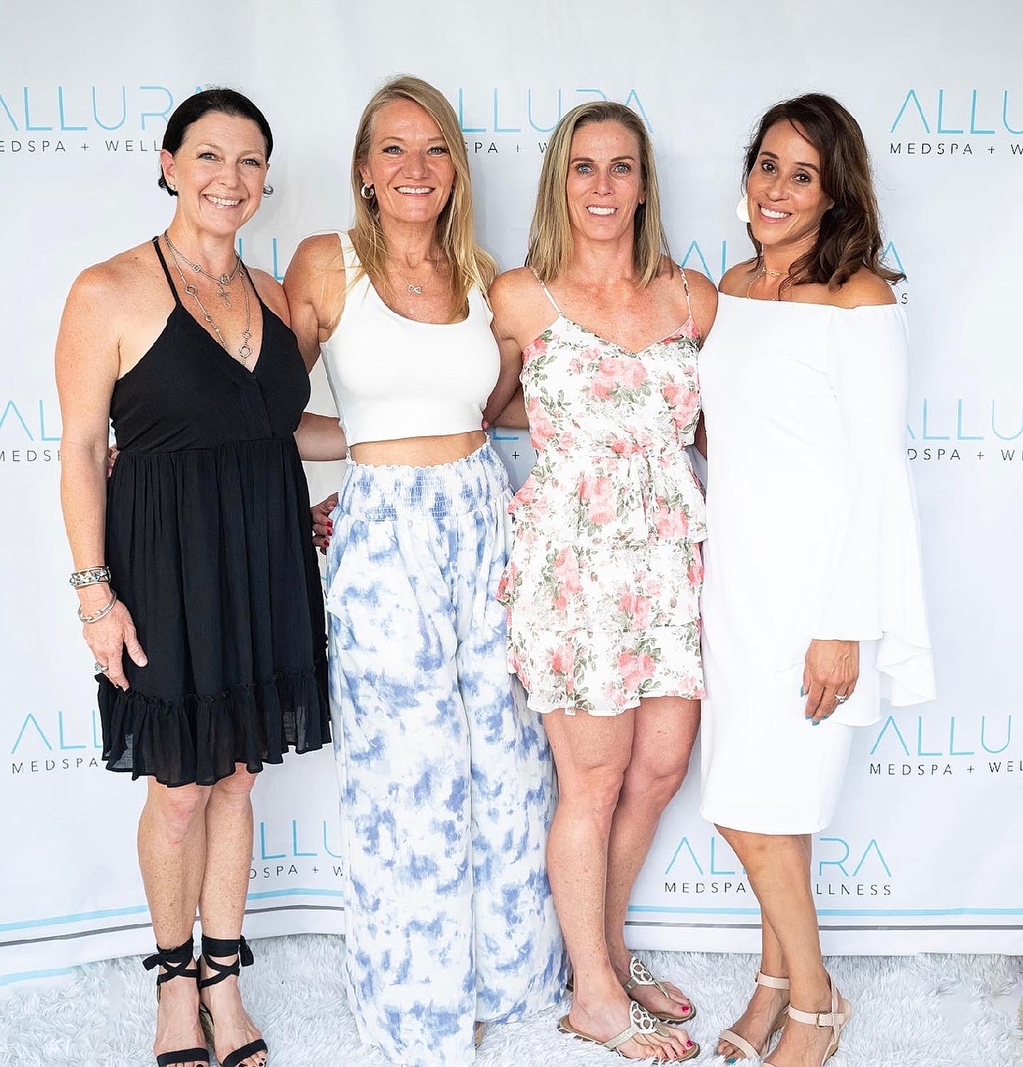 Four women posing at a wellness event.