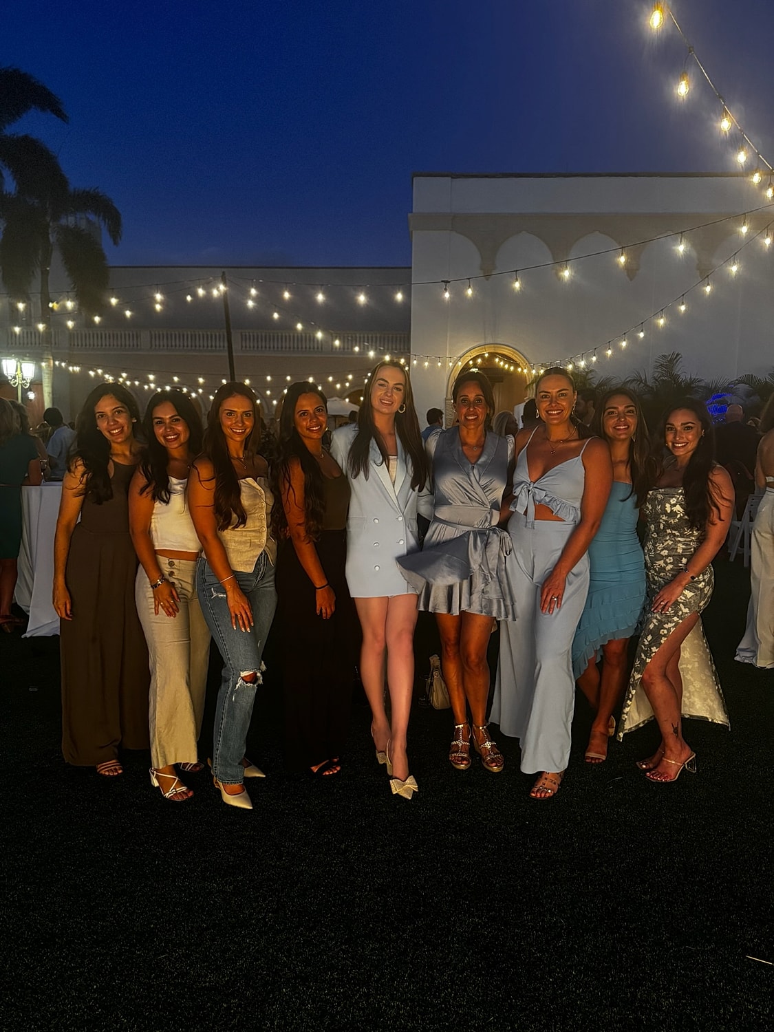 Group of women smiling at evening event.