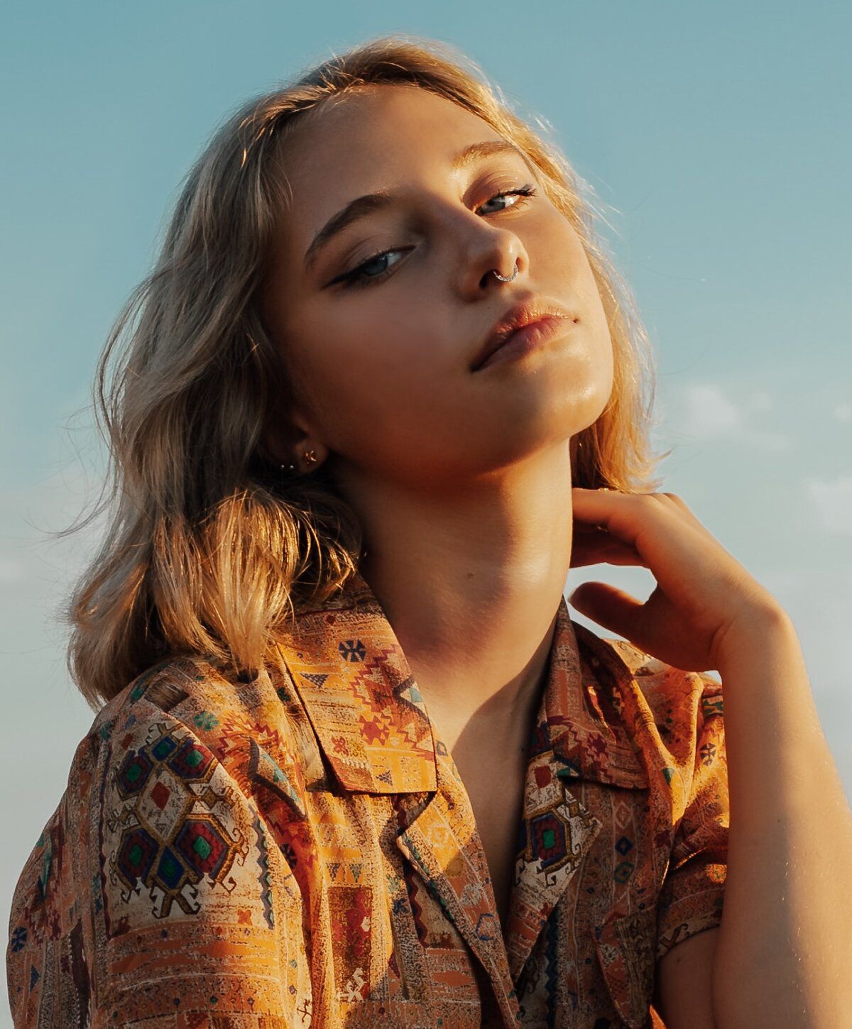 Person with golden hair in patterned shirt.