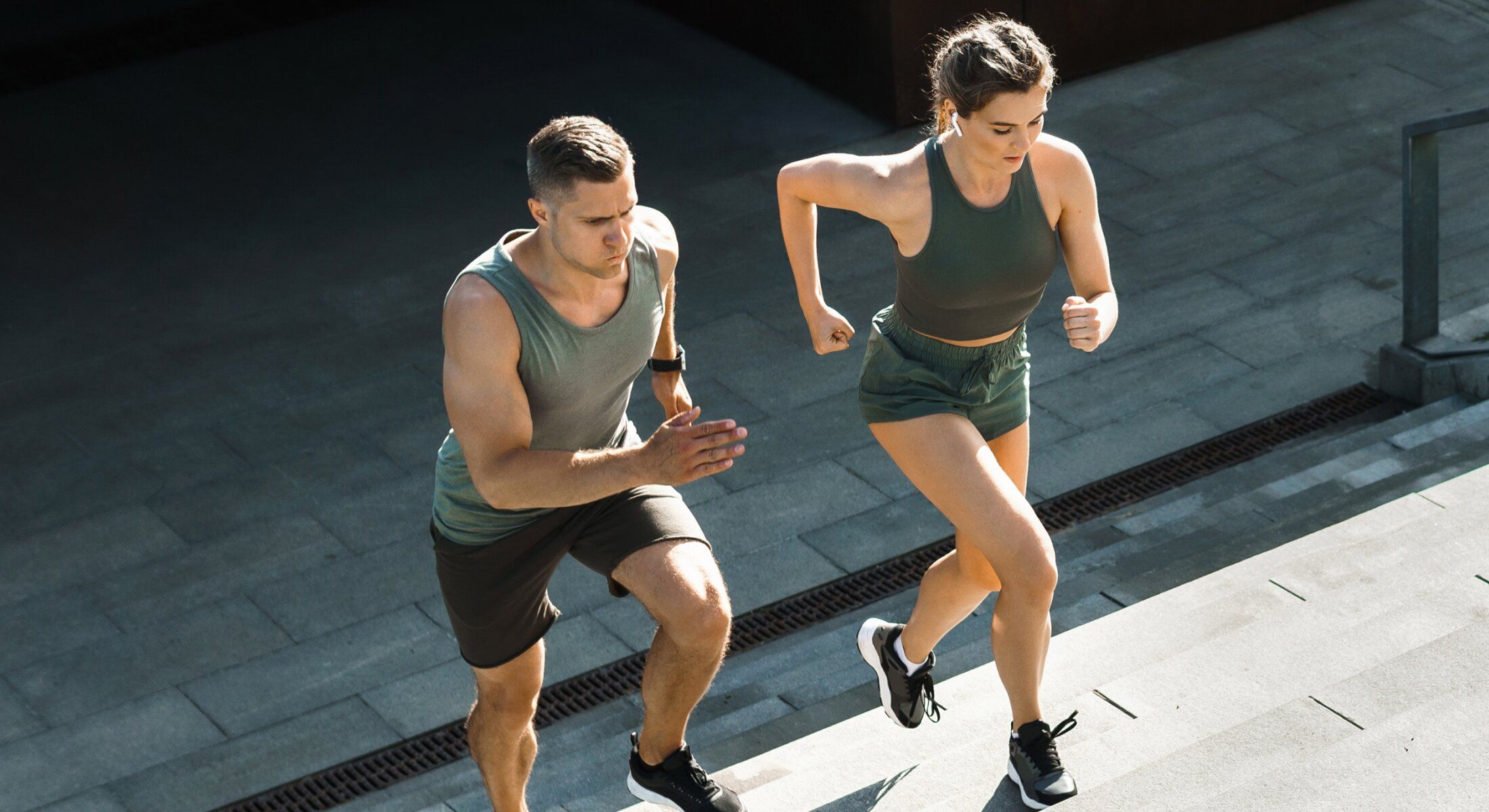 Two people running up outdoor steps.