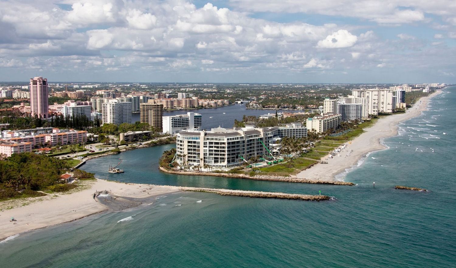 Coastal cityscape with beach and waterfront buildings.
