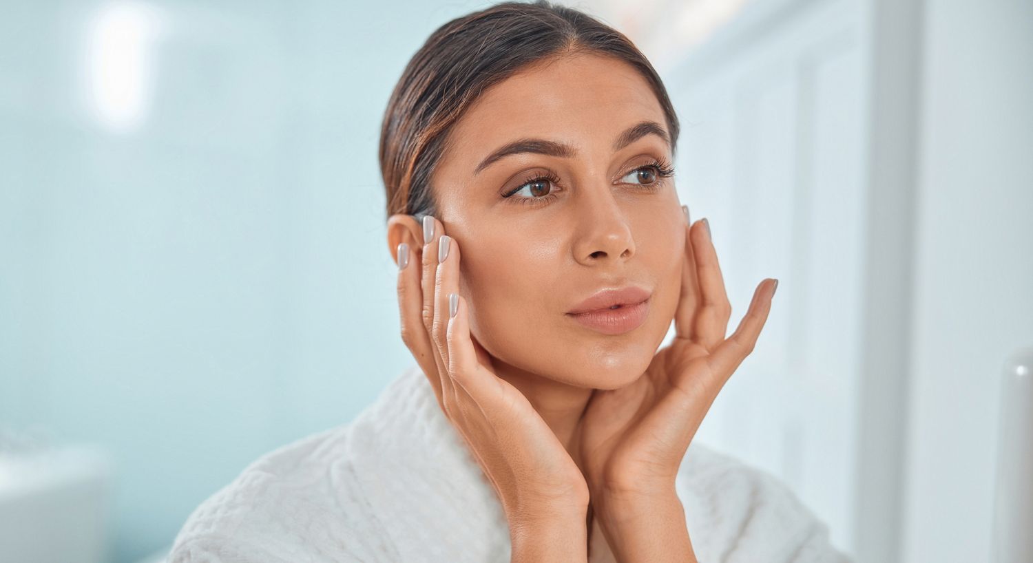 Chemical Peel patient model looking in a mirror and touching her face