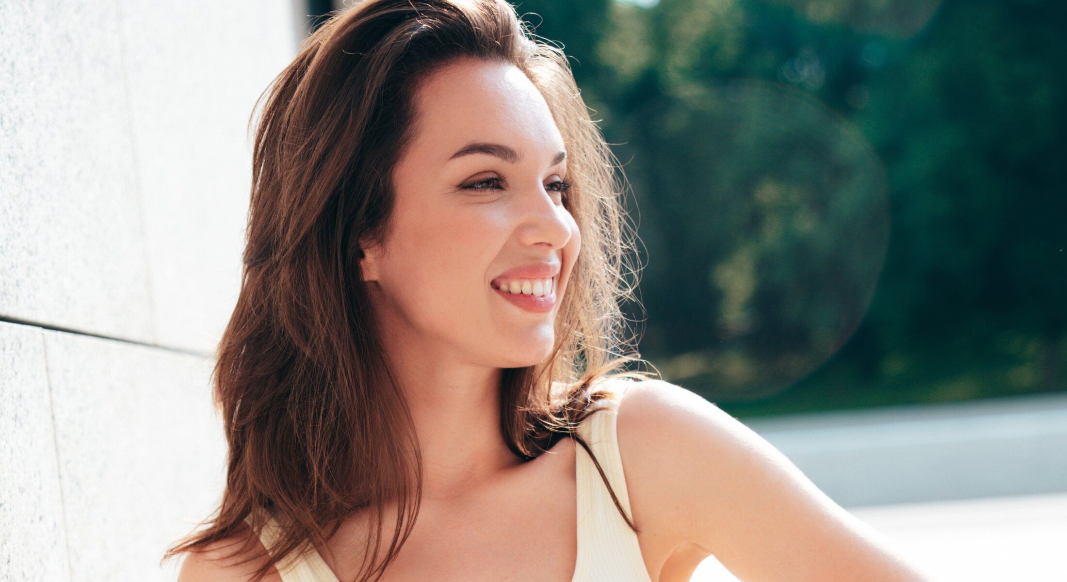 Smiling woman with long hair and natural sunlight.